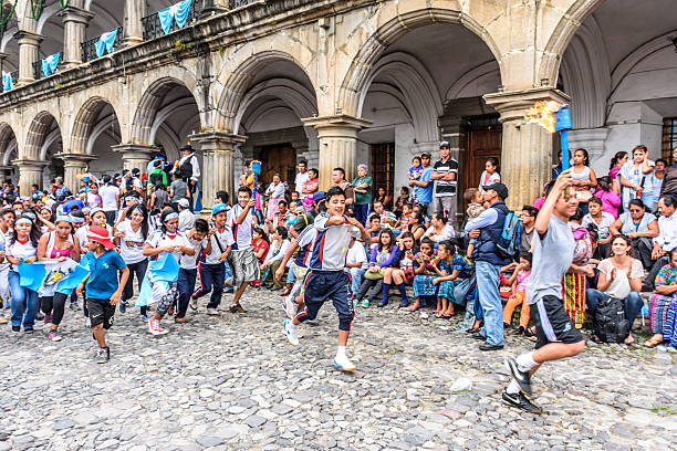 Antigua, Guatemala - September 14, 2015: Locals run by city hall with lit torches during Guatemalan Independence Day celebrations