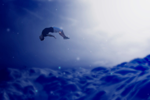 Blue toned image of a young man floating in the air in a dream world.