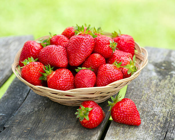 istock basket with strawberries on a garden wooden table 607762458