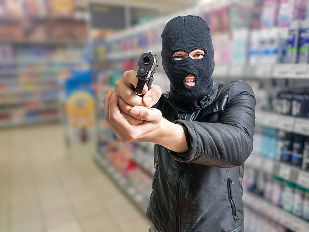 istock Robbery in store. Robber is aiming and threatening with gun. 607763042