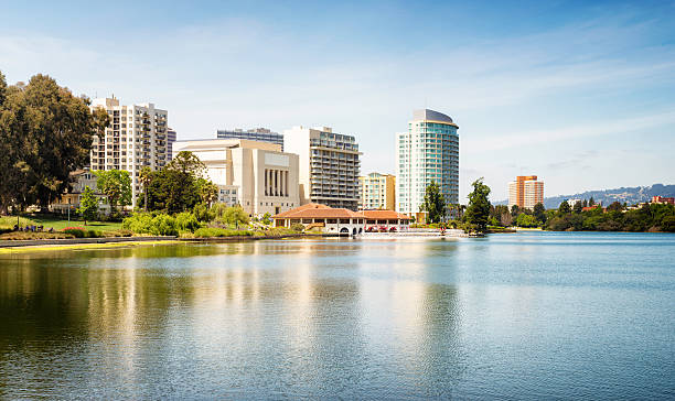 Oakland Lake Merritt panoramic skyline with a row of appatment buildings, temple and shops on the shore.