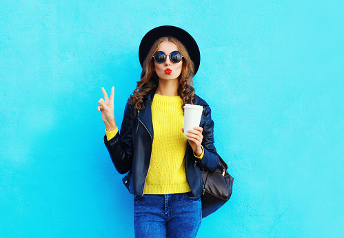 Fashion pretty woman with coffee cup wearing black rock style