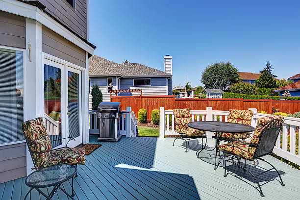 istock Wooden walkout deck with patio table set and barbecue 607764856