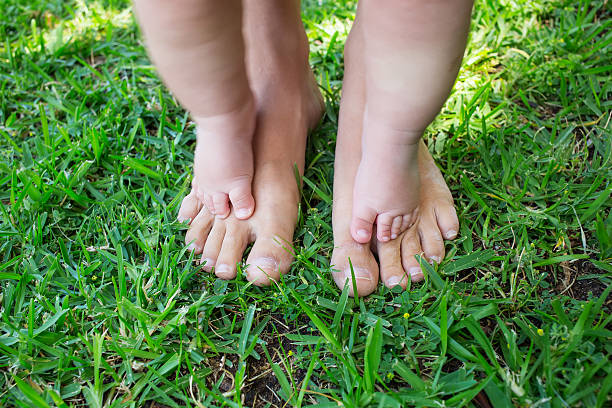 istock Baby boy makes first step at the green grass outdoor 607769964