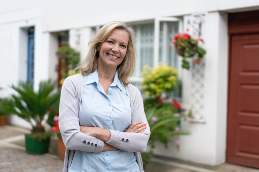 Portrait of a happy woman outside her house looking at the camera smiling