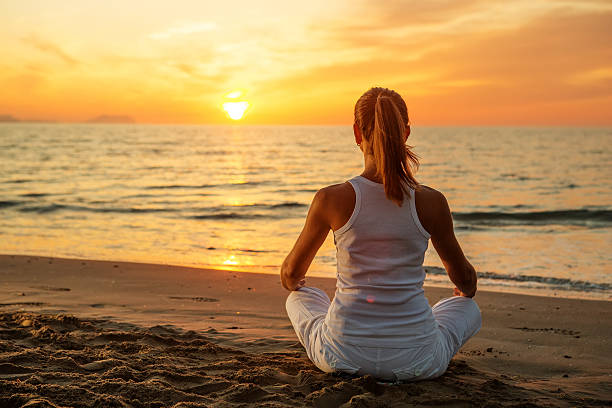 istock Caucasian woman practicing yoga at seashore 607770576