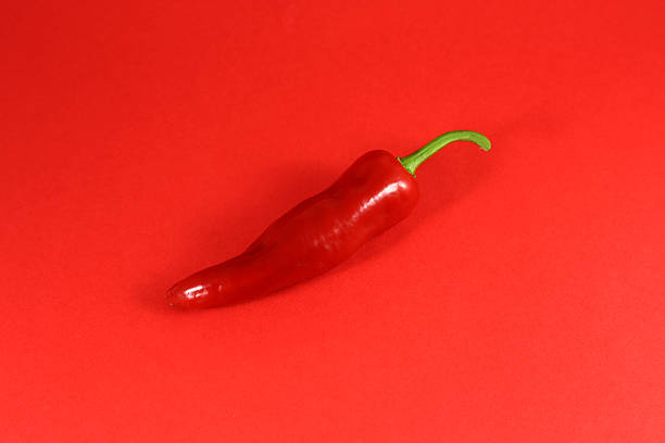 istock chili pepper isolated on a red background 607772074