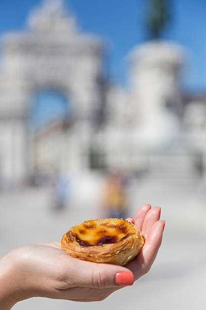 istock Portuguese dessert Pasteis de nata in women hand 607772756