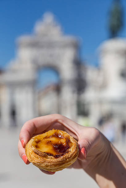 istock Portuguese dessert Pasteis de nata in women hand 607772926