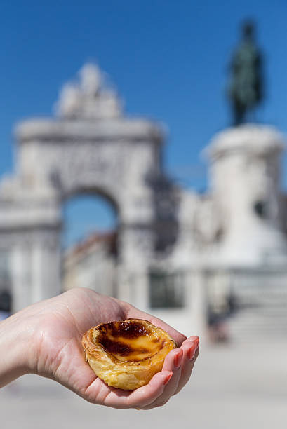 istock Portuguese dessert Pasteis de nata in women hand 607773208