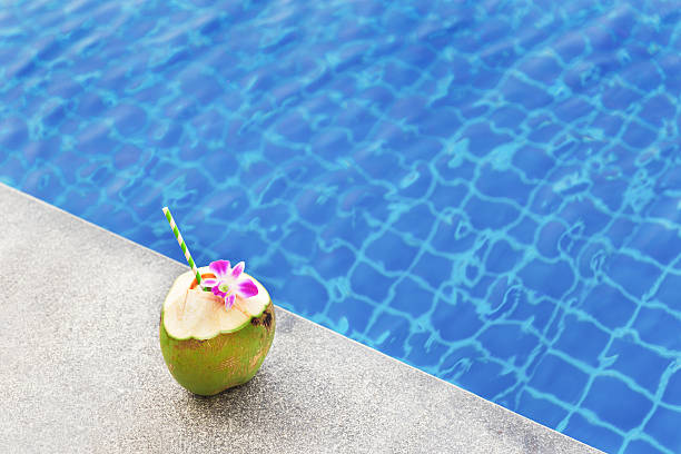 istock Coconut juice with orchid flower on swimming pool 607774592