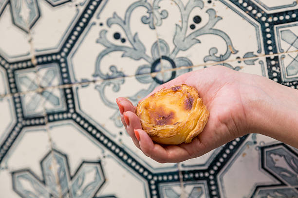 istock Portuguese dessert Pasteis de nata in women hand 607775660