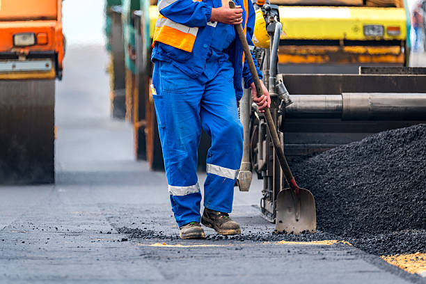 The workers and the asphalting machines stock photo