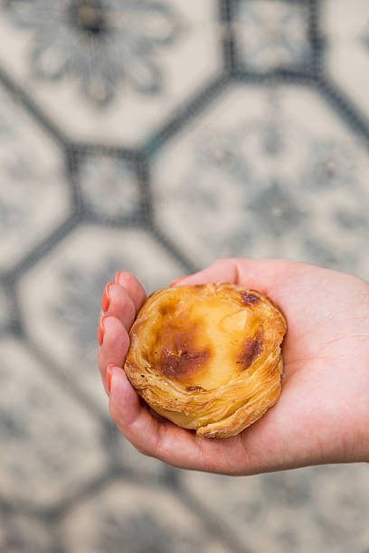 istock Portuguese dessert Pasteis de nata in women hand 607776166