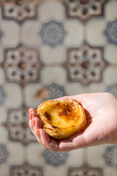istock Portuguese dessert Pasteis de nata in women hand 607776274
