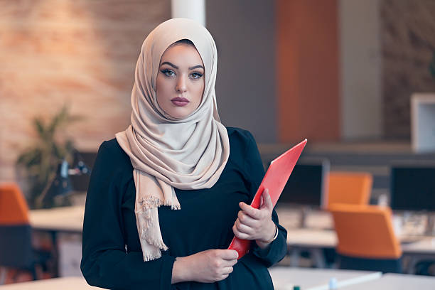 istock Arabian business woman holding a folder in modern startup office 607777480