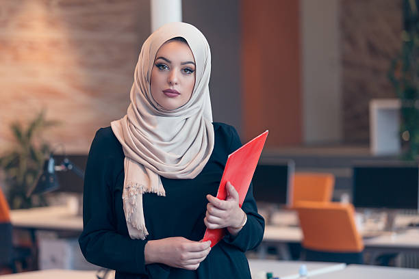 istock Arabian business woman holding a folder in modern startup office 607777546
