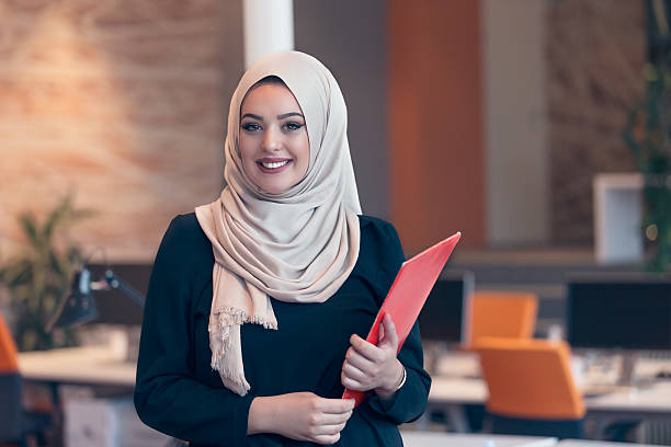 istock Arabian business woman holding a folder in modern startup office 607777592