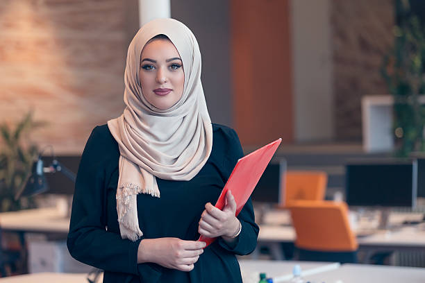 istock Arabian business woman holding a folder in modern startup office 607777664