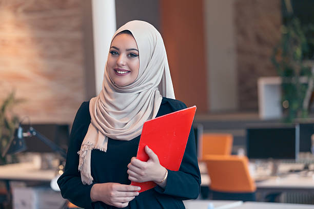 istock Arabian business woman holding a folder in modern startup office 607777702