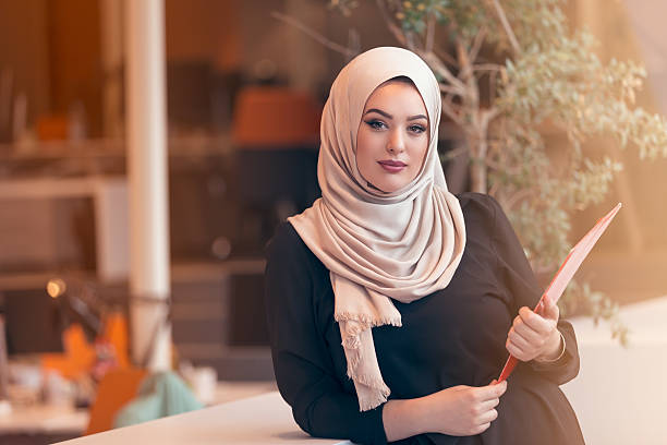 istock Arabian business woman holding a folder in modern startup office 607777956