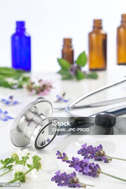 Bottle Of Essential Oil With Medicinal Plant And Stethoscope Stock Photo - Download Image Now