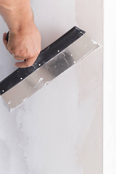 istock house improvement. worker puts finishing layer of stucco on wall 607778106