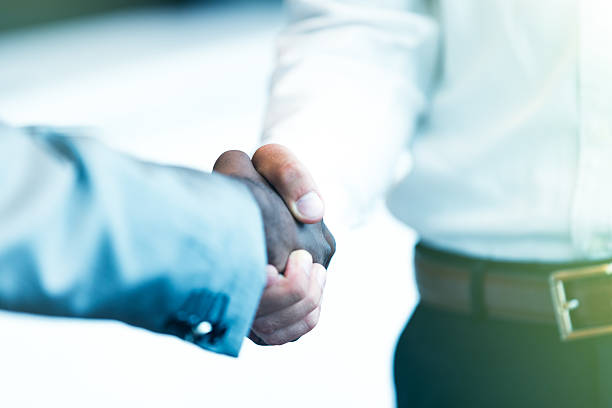 istock Handshake between african and a caucasian man 607778288