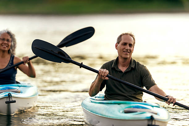 adult male paddling in his kayak - date night imagens e fotografias de stock