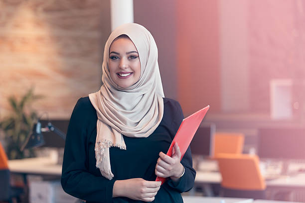 istock Arabian business woman holding a folder in modern startup office 607873398