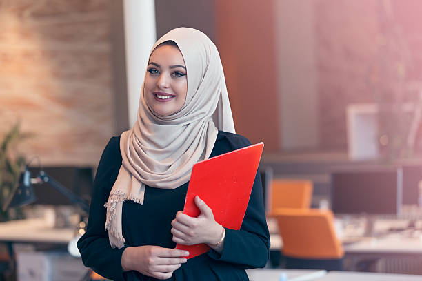 istock Arabian business woman holding a folder in modern startup office 607873676