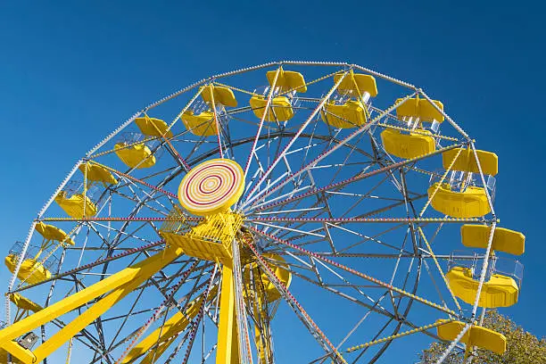 Horizontal image of yellow Ferris wheel at the PotashCorp Playland at Kinsmen Park in Saskatoon.  The park was recently renovated to include new rides for children and the Ferris wheel is a new addition to the park.  The park rides are open throughout the summer.