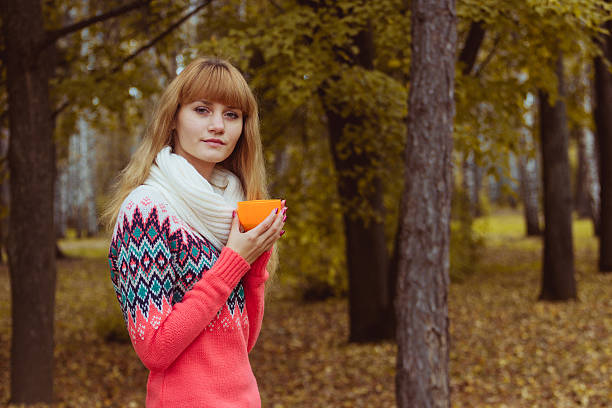 istock Fall concept - autumn woman drinking coffee in park 607874152