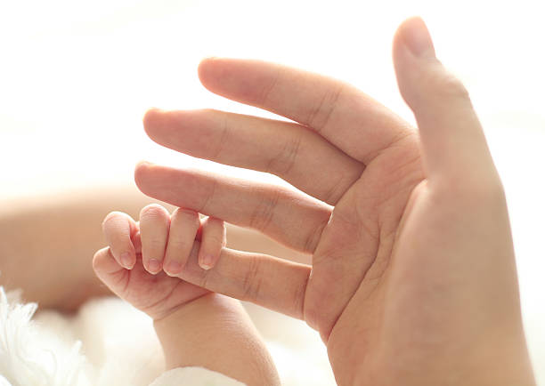 istock mother hand hold baby hand 607878306