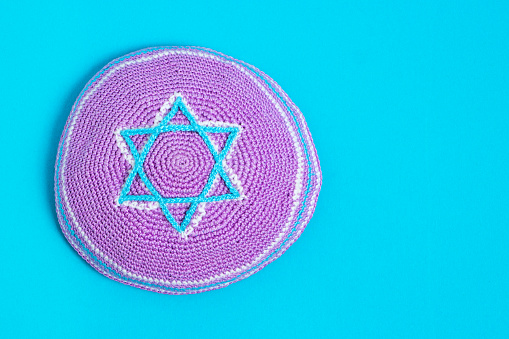 Violet kipa on a blue background, top view. Jewish New Year, Rosh Hashanah.