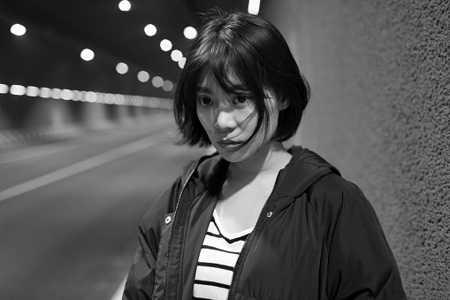 chinese pretty girl standing on the roadside city road tunnel