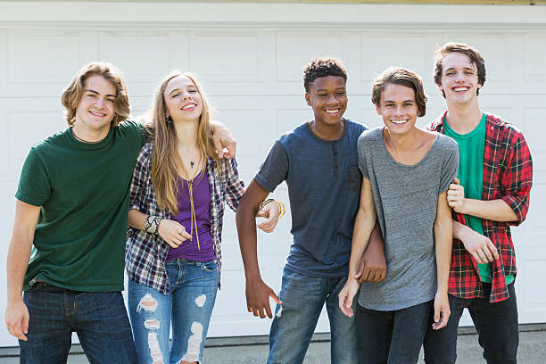 istock Group of five multi-ethnic teenagers hanging out 607884684