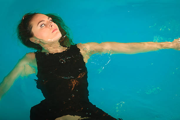 istock Woman dreaming relaxing in swimming pool water. 607885830