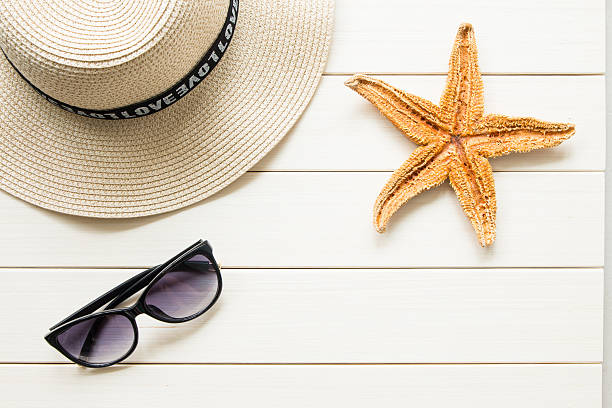 istock Straw hat and sunglasses on wood 607888678