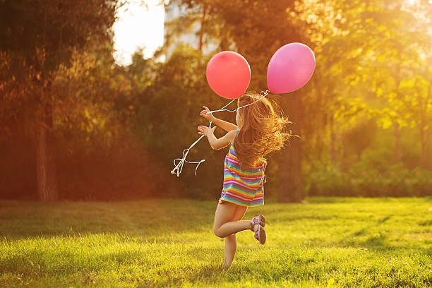 istock Little girl runs with balloons 607890946