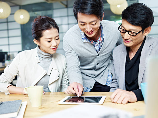 equipo de negocios de jóvenes asiáticos trabajando en la oficina - korean culture fotografías e imágenes de stock