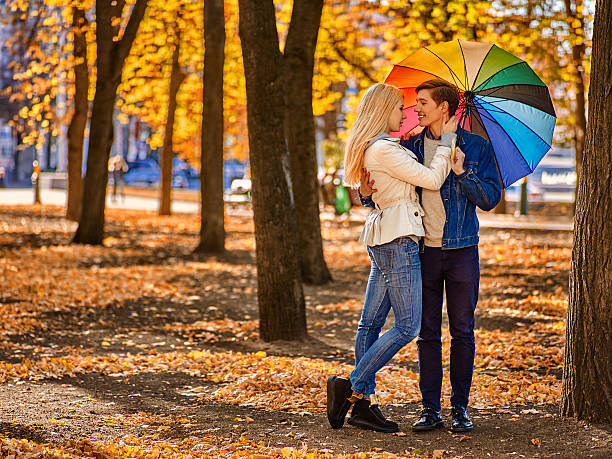 istock Young couple hugging and flirting in park. 607892362