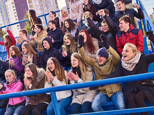 istock Sport fans clapping and singing on tribunes. 607892628
