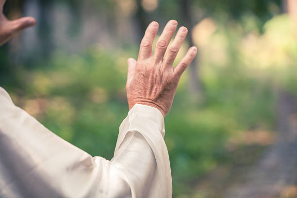 old man practice tai chi in the park