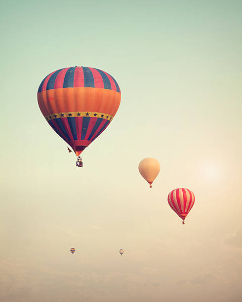 Hot air balloons Vintage hot air balloon flying on sky with fog - retro filter effect style hot air balloon photos stock pictures, royalty-free photos & images