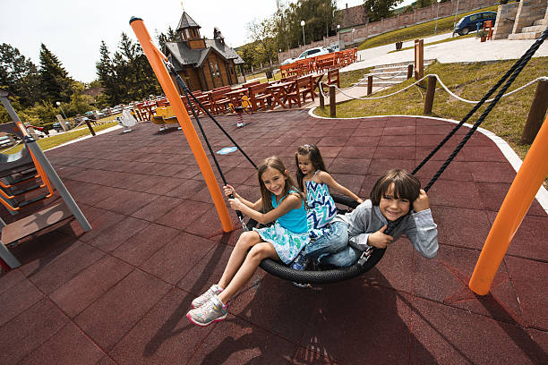 istock Three children having fun while swinging in a knitted swing. 607899782