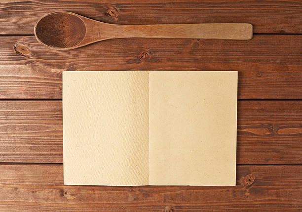 istock Wooden spoon next to recipe book 607904936