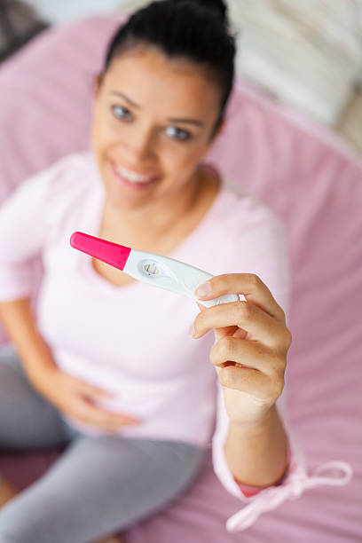istock excited young woman with pregnancy test 607904960