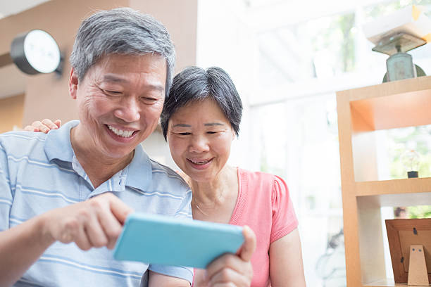 old couple look smaprt phone the old couple look smaprt phone happily, asian china chinese ethnicity smiling grandparent stock pictures, royalty-free photos & images