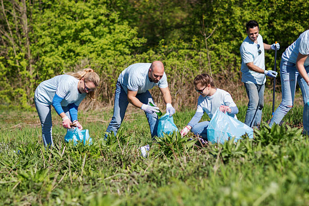 volunteers with garbage bags cleaning park area